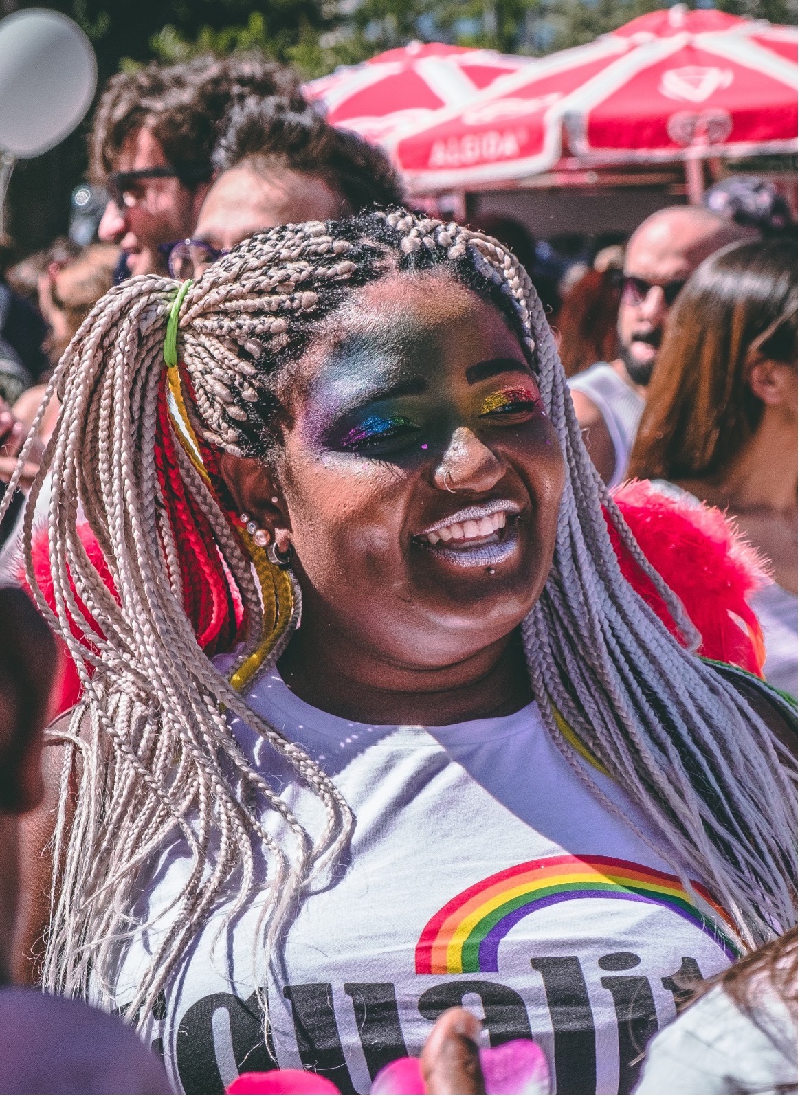 young woman in rainbow makeup at an LGBTQ+ gathering